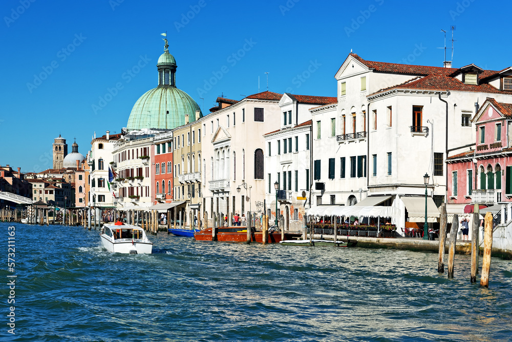 Grand Canal of Venice at sunny day, boats, San Simeone Piccolo church, also called San Simeone e Giuda, in the background and blue sunny sky.