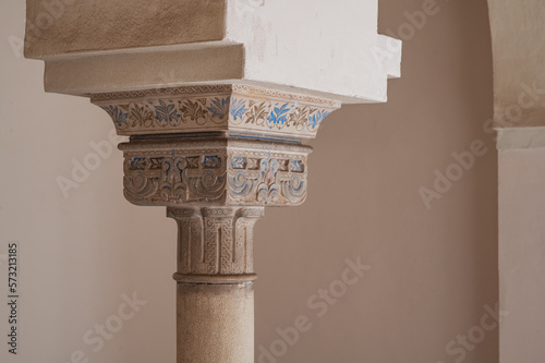 Ornate column with blue painted details in a courtyard at Nasrid Palace, Alcazaba, Spain photo