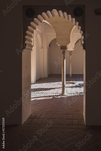 View on the courtyard with ornate columns through the arched doorway in Nasrid Palace, Alcazaba, Malaga, Spain