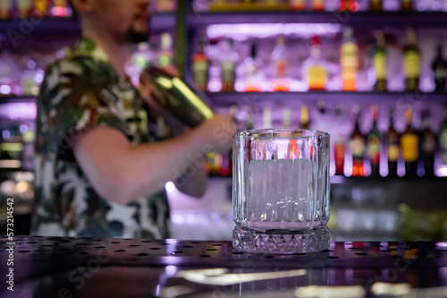 empty glass with ice on a bar counter in bar or pub