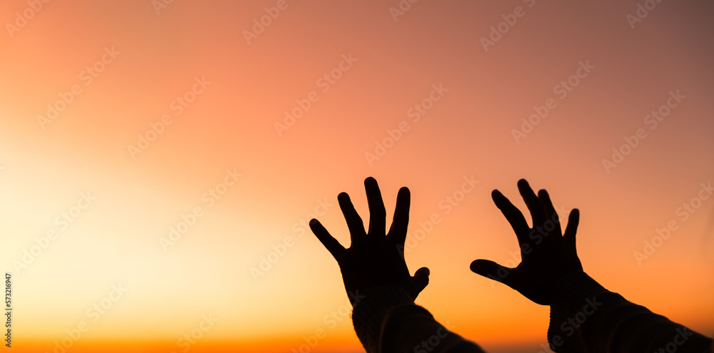 Silhouette of woman hand praying spirituality and religion, female worship to god. banner with copy space. Religious people are humble to God. Christians have hope faith and faith in god.