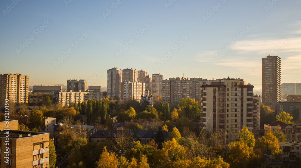 Fototapeta premium Urban beautiful landscape - panoramic view of residential multi-storey modern houses among autumn trees on a sunny October day in Reutov Moscow region and copy space