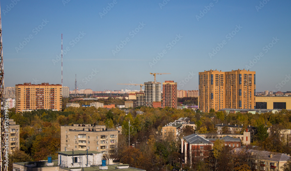The city of Reutov in the Moscow region panoramic top view with modern residential buildings with trees with golden foliage on a sunny autumn day and blue sky above the horizon and space for copy