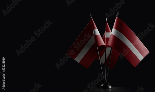 Small national flags of the Latvia on a black background