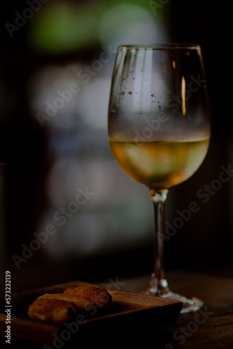 a glass of white wine in a dark room