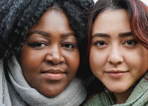 Young multiracial women looking on camera outdoor during winter time - Concept of diversity and friendship