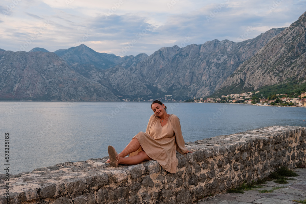 beautiful woman in a dress smiling, admiring the landscape, Kotor bay, Montenegro 