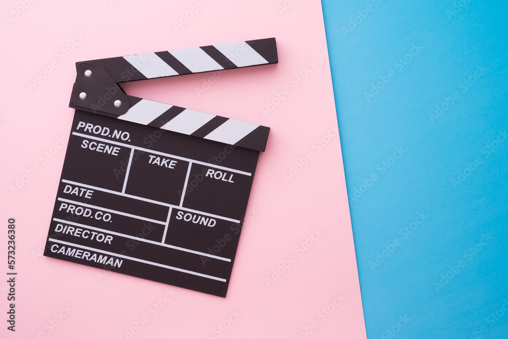 Cinema clapperboard on pink blue colorful background - Movie cinema entertainment concept.