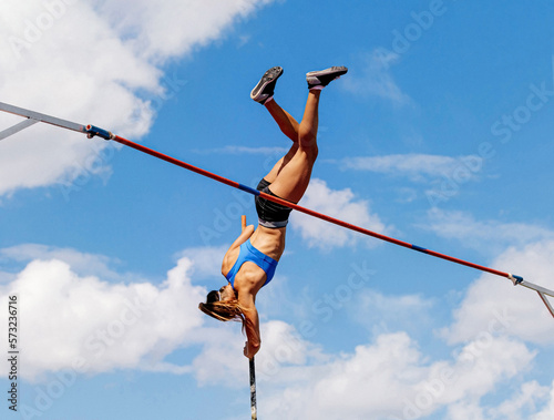 woman athlete in pole vault background blue sky