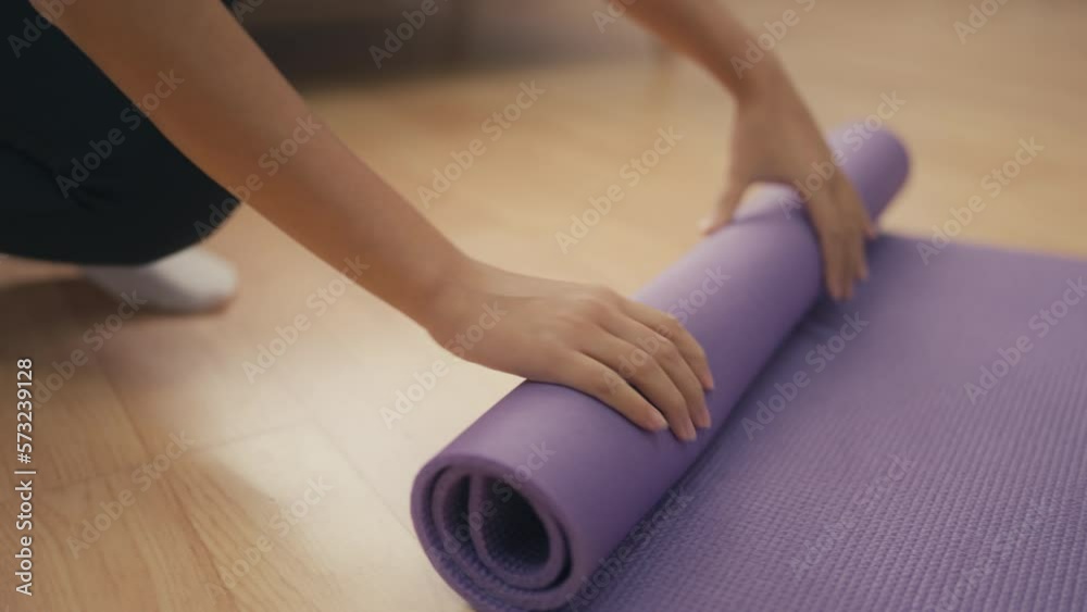 Woman unrolling fitness mat for practicing yoga, healthy lifestyle, sport