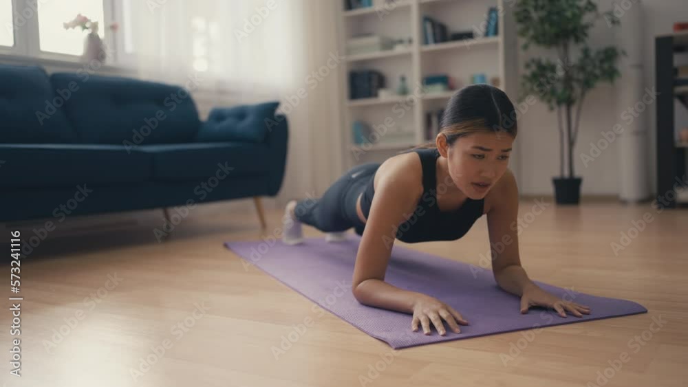 Young Asian woman having difficulty with planking exercise, feeling muscle pain Young Asian woman having difficulty with planking exercise, feeling muscle pain