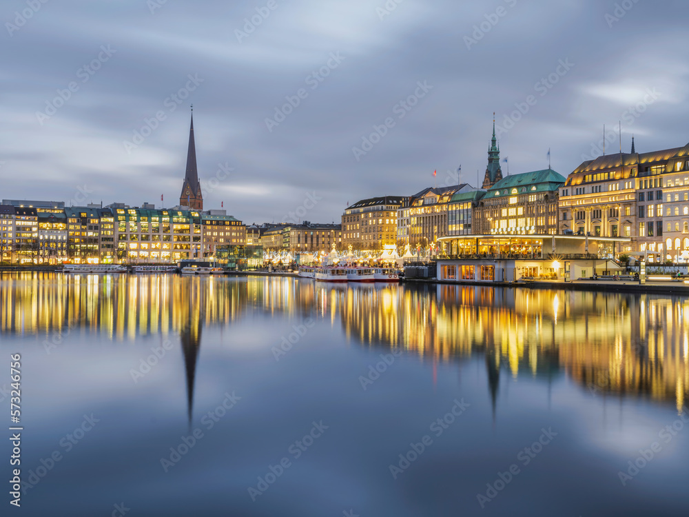 Hamburg city centre illuminated on lake Binnenalster at dusk, Germany