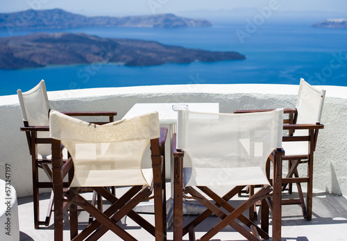 A small table and four chairs with scenic view of caldera santorini 