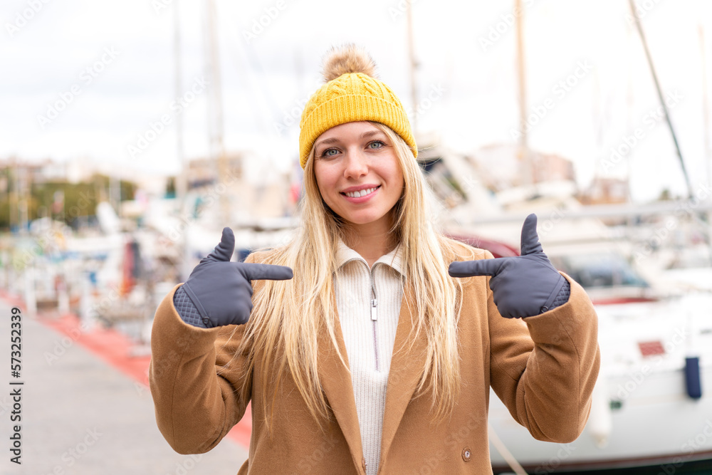 Young pretty blonde woman wearing winter jacket at outdoors with surprise facial expression Young pretty blonde woman wearing winter jacket at outdoors with surprise facial expression