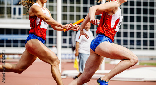 relay race passing of baton women athletes runners