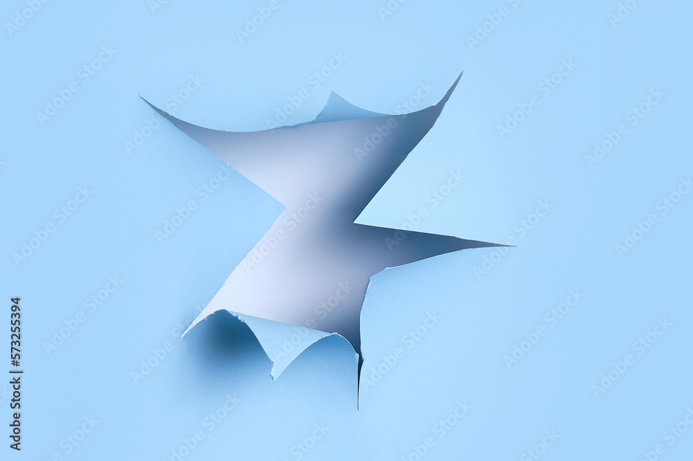 Hole in studio blue background. Torn paper background, copy space Hole in studio blue background. Torn paper background, copy space