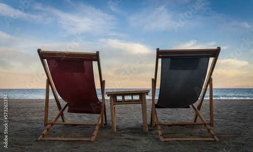 Dos hamacas en la playa en un día soleado con una mesa en medio
