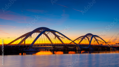 A bridge in the city at night. The bridge on the blue sky background during the blue hour. Architecture and design. The Enneaus Heerma Bridge, Amsterdam, the Netherlands.