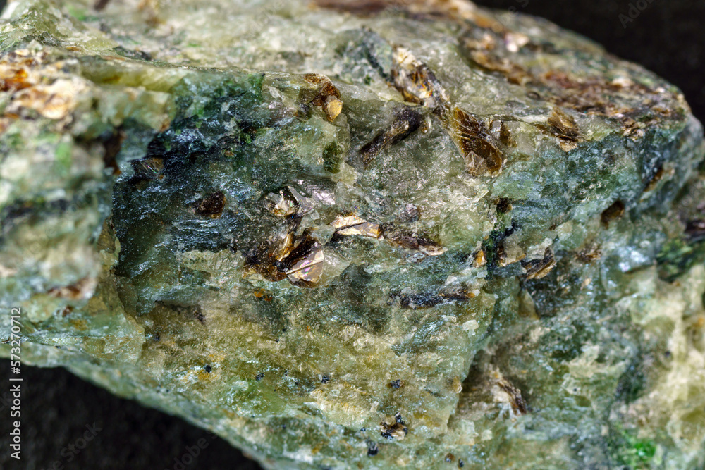 Rock with peridot olivine mineral, black background. Close-up, macro