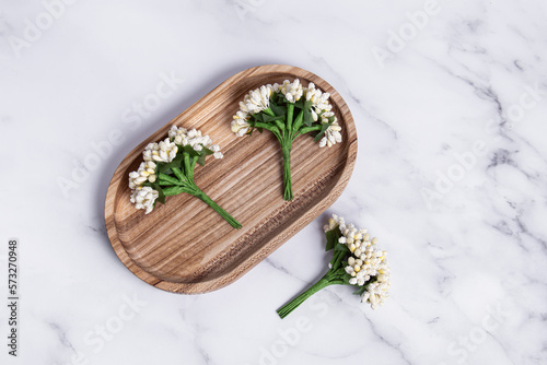 Fototapeta Naklejka Na Ścianę i Meble -  Decorative artificial flowers for creativity on wooden tray. Top view. Decorative bouquets