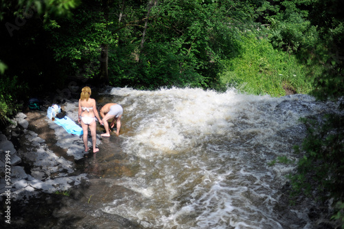 un couple se baigne dans une rivi  re pr  s d une cascade en   t  