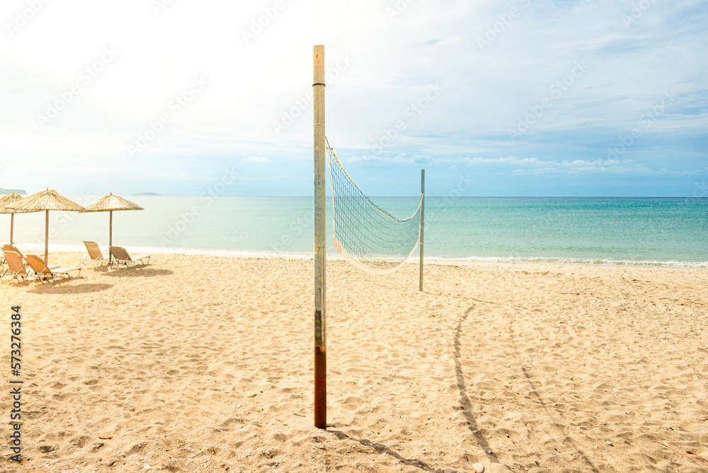 Beach volleyball net on a golden sand beach with turquoise sea waters and bright blue sunny sky Beach volleyball net on a golden sand beach with turquoise sea waters and bright blue sunny sky