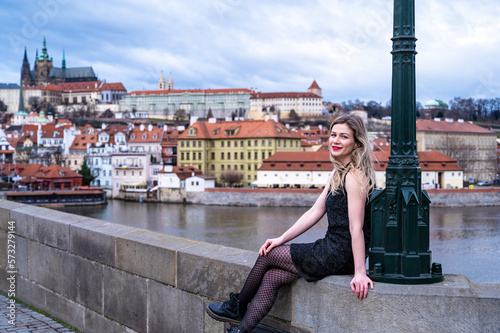 beautiful woman posing on the Charles Bridge on the background of Prague Castle 
