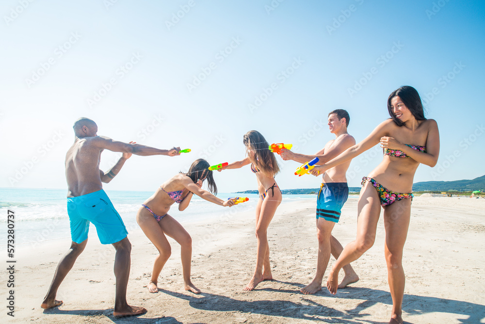 Happy multiethnic group of friends having summer vacation and having fun on the beach - Young people bonding together at the sea Happy multiethnic group of friends having summer vacation and having fun on the beach - Young people bonding together at the sea