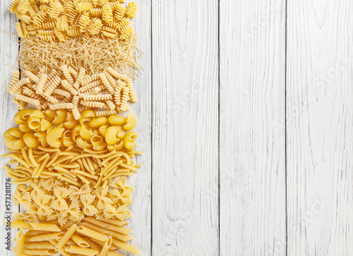 Obraz na płótnie Different types and shapes of Italian pasta on white wooden background w salonie