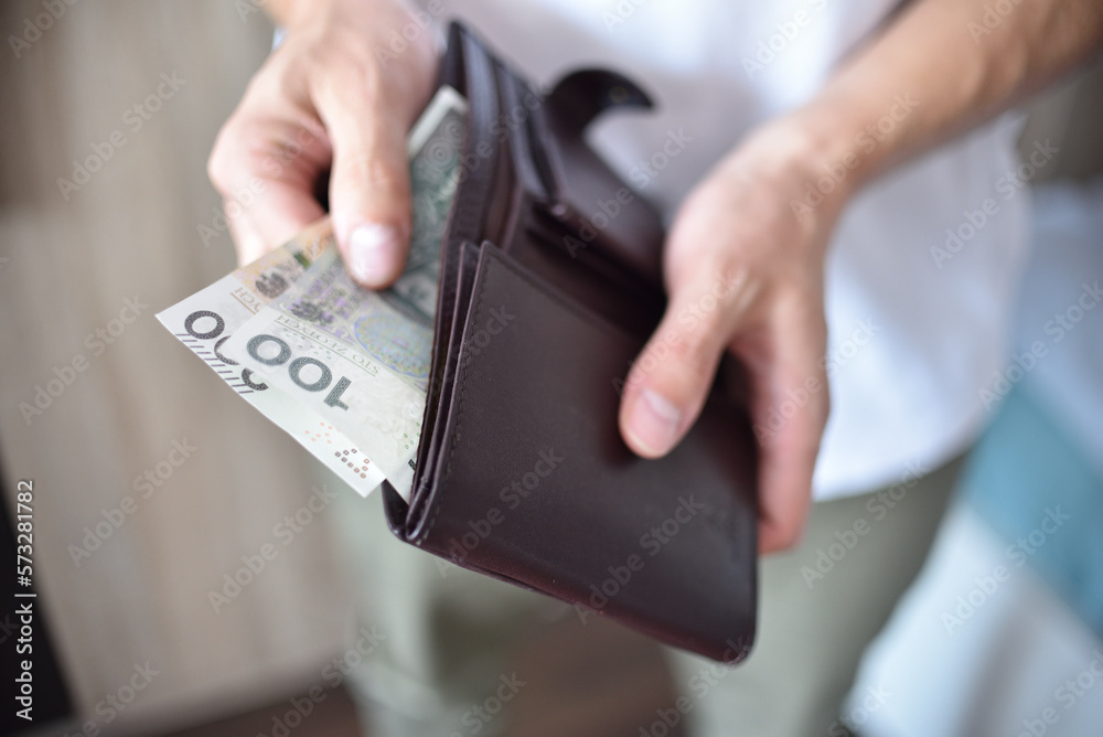 Mężczyzna trzymający portfel z gotówką. - obrazy, fototapety, plakaty 