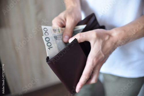 Mężczyzna trzymający portfel z gotówką.
