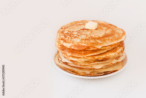 Staple of yeast fluffy pancakes with butter. Spring holiday Traditional Russian Shrovetide Maslenitsa week or pancake tuesday holiday. american crepes isolated on white gray background. side view