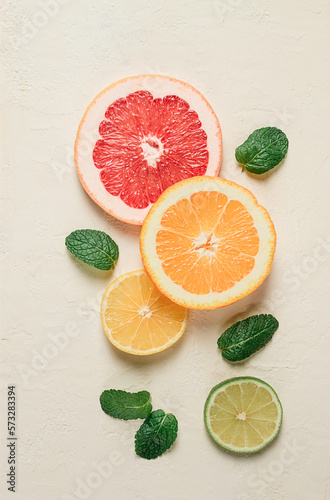 Fototapeta Naklejka Na Ścianę i Meble -  Food concept, wallpaper, sliced citrus fruits, top view, on a light table, with mint leaves, food background