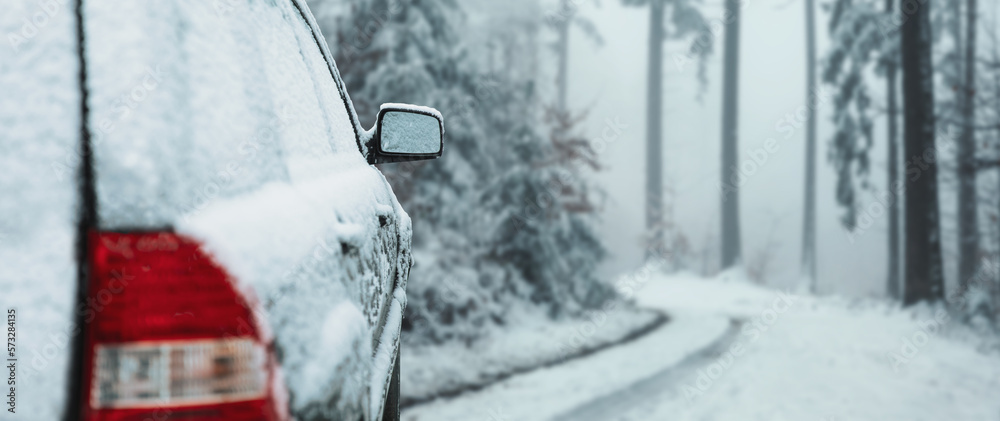 Zbliżenie ośnieżonego samochodu zimą na zaśnieżonej drodze w lesie - obrazy, fototapety, plakaty 