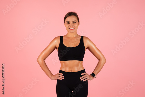 Body Shaping Concept. Smiling Young Woman In Sportswear Posing On Pink Background © Prostock-studio