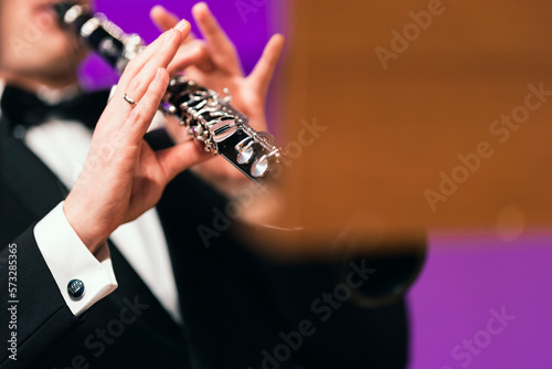 A musician playing the clarinet during a performance dressed in concert black