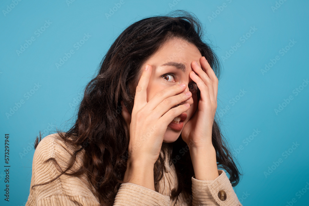 Frightened shocked pretty millennial european female student covering her face with hands Frightened shocked pretty millennial european female student covering her face with hands