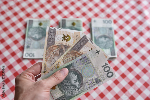 Mężczyzna trzymający gotówkę, w tle inne banknoty.