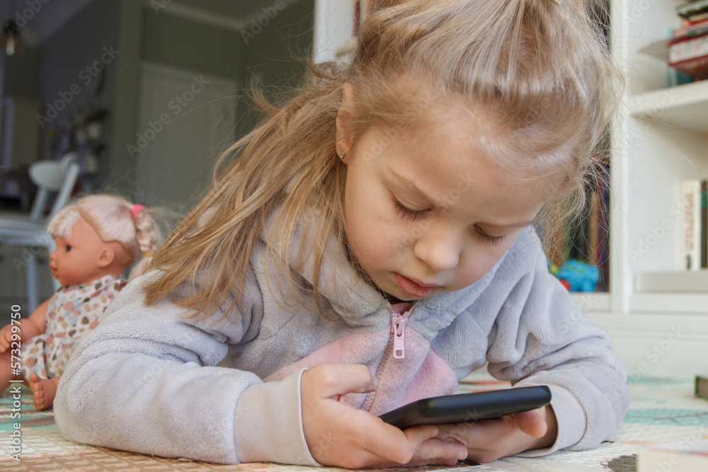 Little cute child holds a smartphone with a green screen. Concept of education online Little cute child holds a smartphone with a green screen. Concept of education online