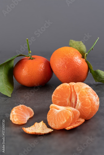 fresh tangerines with leaves on a dark background.