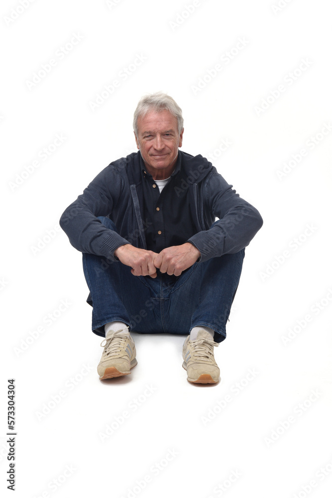 front view of a man sitting on the floor with legs folded and smiling and looking at camera on white background front view of a man sitting on the floor with legs folded and smiling and looking at camera on white background