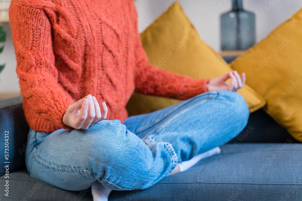 Young woman meditating on sofa Young woman meditating on sofa