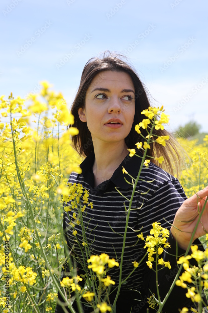 Close up photo of young woman in yellow flower field. Close up photo of young woman in yellow flower field.