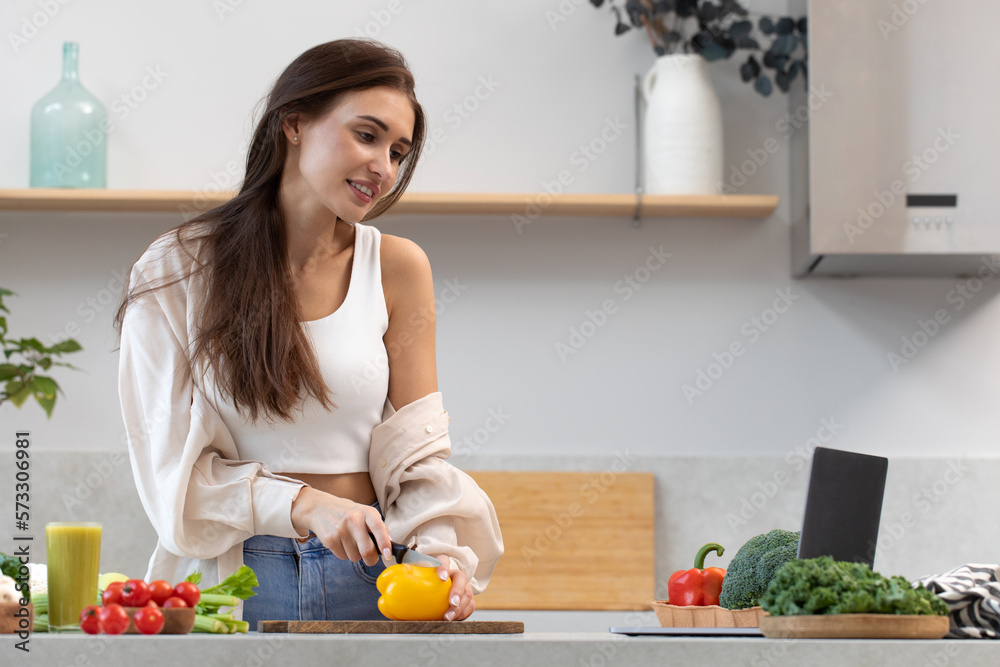 An attractive woman is watching a cooking class on cooking a vegetarian dish. Video recipe An attractive woman is watching a cooking class on cooking a vegetarian dish. Video recipe