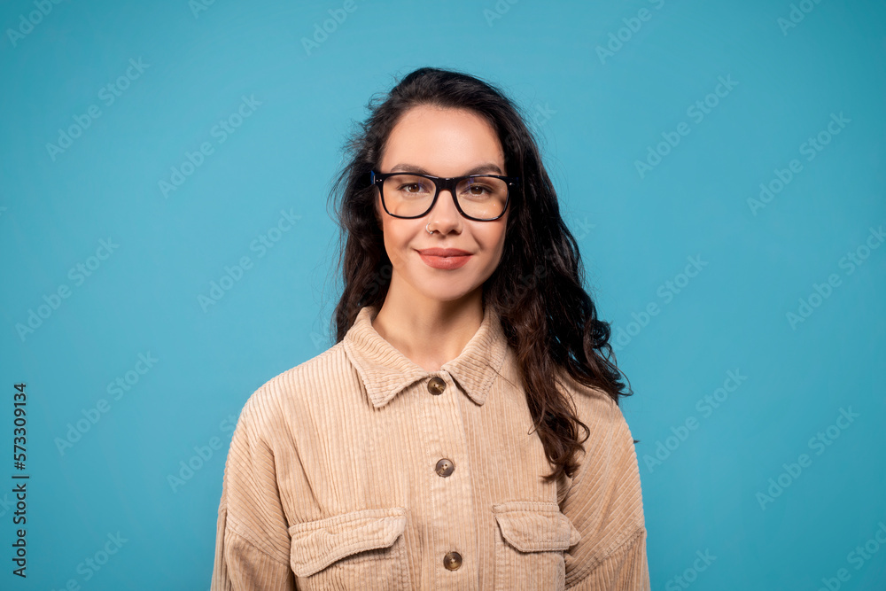 Portrait of glad pretty smart millennial european female student in glasses looking at camera
