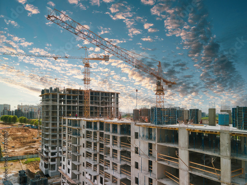 Φωτογραφία Construction cranes and top of the building with construction workers