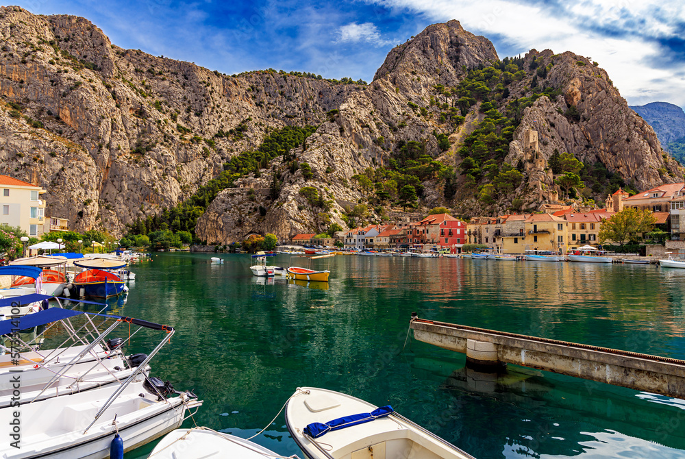Croatia, City of Omiš, a popular tourist destination for trekking and rafting on the Cetina river. Mountains, river, pleasure boats.
