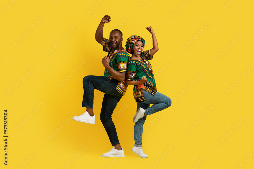 Positive happy black lovers celebrating success on yellow, gesturing