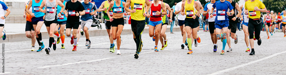 marathon runners running race in city a large group of athletes marathon runners running race in city a large group of athletes