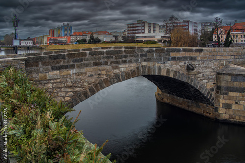 Old stone bridge and center of Pisek town in cloudy winter morning